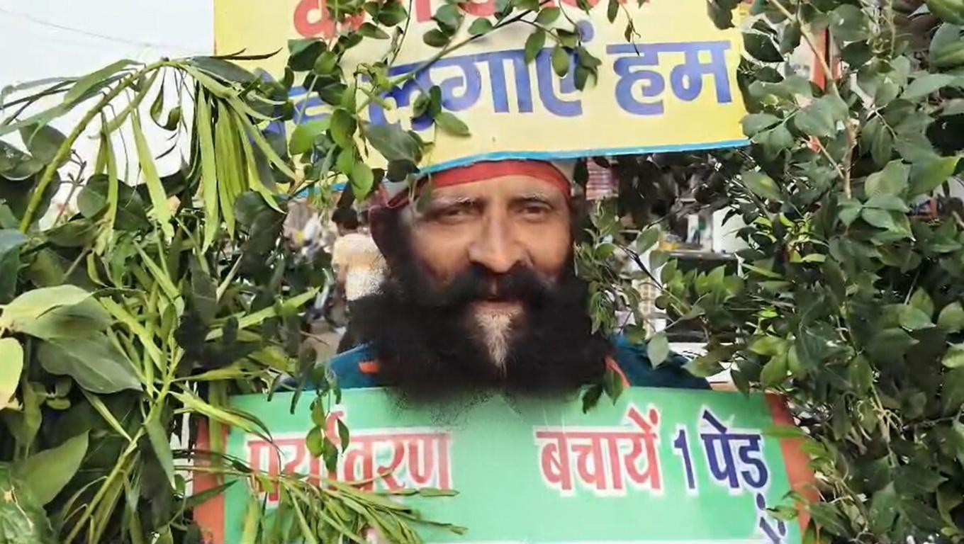 प्रयागराज : शरीर पर स्लोगन लिखकर और पेड़-पौधे लिए अनोखे अंदाज में लोगों को जागरूक कर रहा शख्स